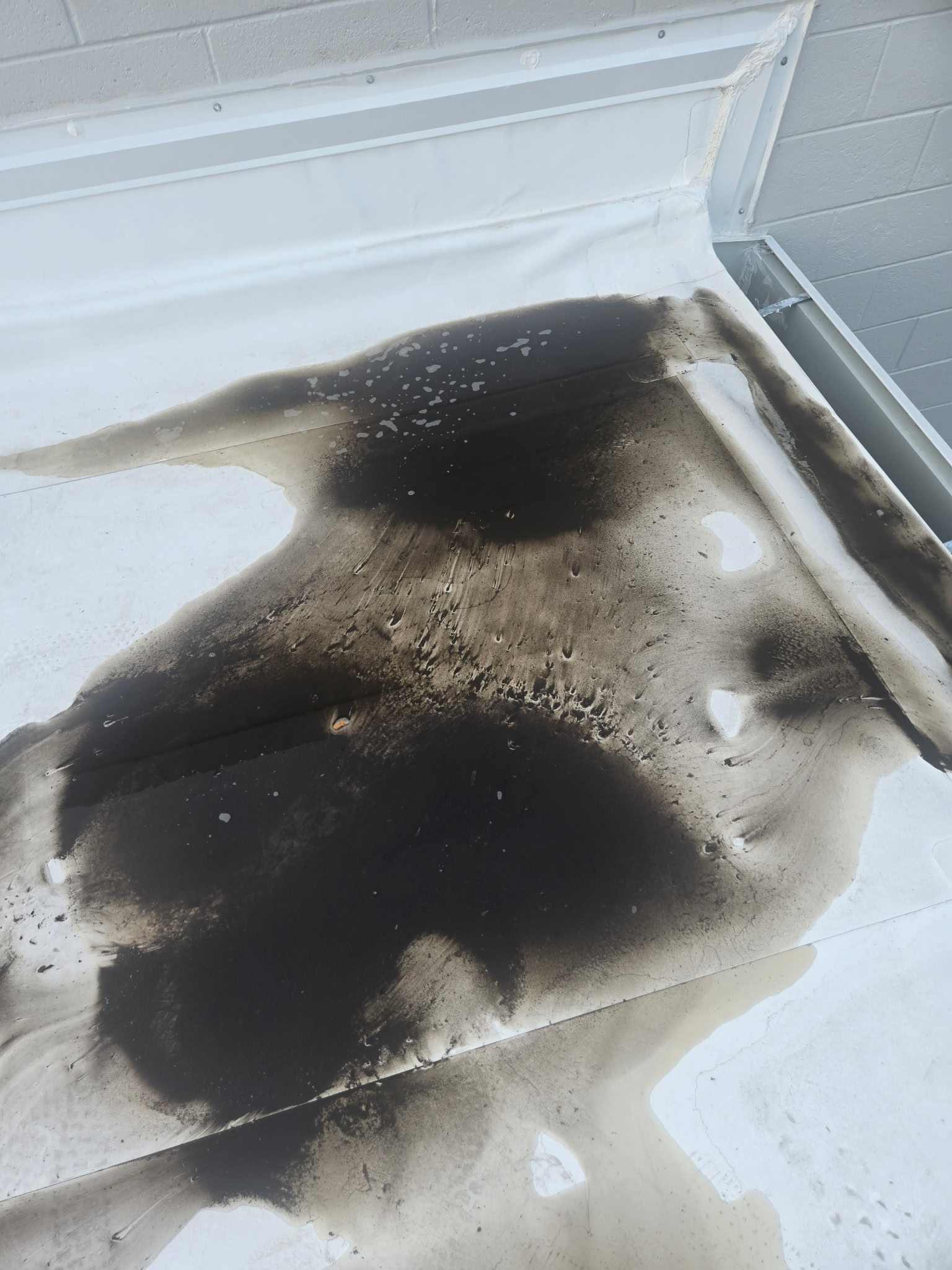 Coil-cleaning runoff on a commercial rooftop during service